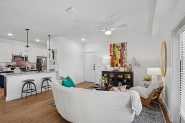 Austin apartment for rent - A modern living room with a white couch and a kitchen area in the background.
