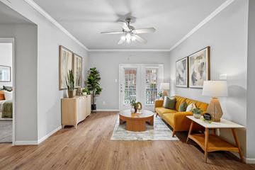 Houston apartment for rent - A living room with a yellow couch and wooden floors.