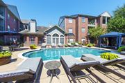 Houston apartment for rent - A pool surrounded by lounge chairs in front of the leasing office at The Inverness Apartments in Houston, TX