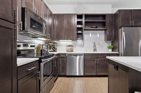Dallas apartment for rent - A kitchen with brown cabinets and stainless steel appliances at Knox Heights Apartments in Dallas, TX