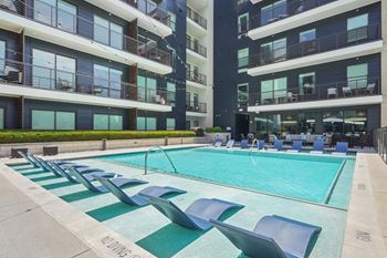 Resort-style swimming pool with poolside loungers