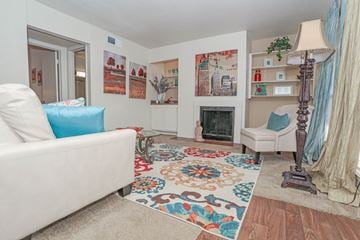 Shreveport apartment for rent - A living room with a white couch and a colorful rug.