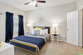 Plano apartment for rent - a bedroom with a bed and a ceiling fan