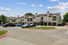 Plano apartment for rent - A large building with a parking lot in front of it.