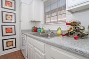 Shreveport apartment for rent - Furnished model apartment kitchen with double basin sink and white cabinets at Magnolia apartments in Shreveport, LA