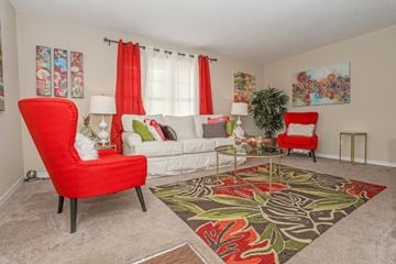 Shreveport apartment for rent - A living room with a red chair and a white couch.
