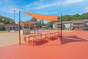 Shreveport apartment for rent - Picnic benches and a communal barbeque in a paved area at The Marq in Shreveport, LA