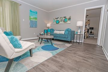 Shreveport apartment for rent - A living room with a white chair and a blue couch.