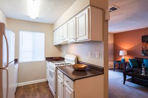 Sandy Springs apartment for rent - a kitchen with white cabinets and a stove and a refrigerator at Dunwoody Pointe in Sandy Springs, GA