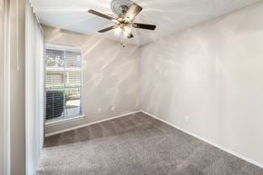 Dallas apartment for rent - an empty bedroom with a ceiling fan and a window