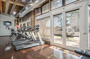 Dallas apartment for rent - Murray Building gym equipped with cardio equipment and large windows | Deep Ellum Lofts in Dallas, TX