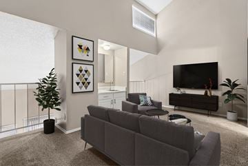 Dallas apartment for rent - A living room with a grey couch and a flat screen TV mounted on the wall.