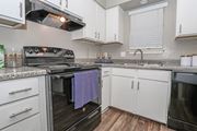 Bossier City apartment for rent - A kitchen with a black oven and white cabinets in our model at The Oasis apartments in Bossier City, LA