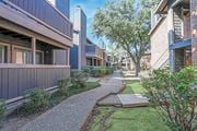 Shreveport apartment for rent - Walkways in between apartments with lush landscaping at The Pearl apartments in Shreveport, LA