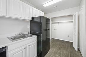 Roswell apartment for rent - Kitchen with white cabinets and washer and dryer connections in C2b floor plan at Riverwood Crossing apartments in Roswell, GA.