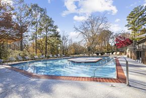 Roswell apartment for rent - A pool surrounded by trees in a sunny day at Riverwood Crossing apartments in Roswell, GA.