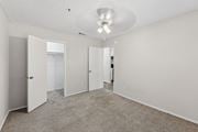 Wylie apartment for rent - A spacious room with carpeted floor and white walls, featuring a ceiling light and four doors.