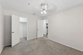 Wylie apartment for rent - A spacious room with carpeted floor and white walls, featuring a ceiling light and four doors.