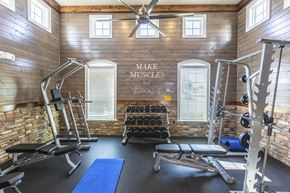 Titusville apartment for rent - a gym with weights and exercise equipment in a building with wooden walls