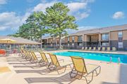 Shreveport apartment for rent - Yellow lounge chairs are lined up by our pool at Stone Canyon apartments in Shreveport, LA.