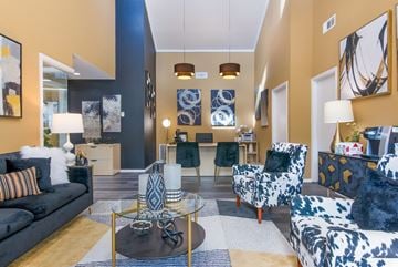 Shreveport apartment for rent - A living room with a black and white patterned sofa, a black and white patterned chair, and a glass coffee table with a metal base.