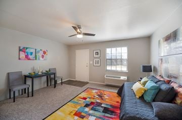 Shreveport apartment for rent - a living room with a couch and a desk and a ceiling fan