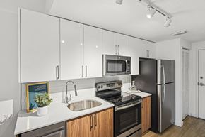 West Miami apartment for rent - Studio Sixty2 kitchen with white cabinets and stainless steel appliances at Twenty2 West luxury apartments in Miami, FL
