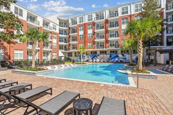 Pool plaza surrounded by elegant landscaping with mosaic tile wall and poolside terrace