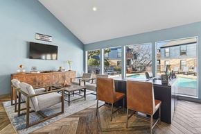 Arlington apartment for rent - A leasing office with chairs and a large window at Vine Apartments in Arlington, TX