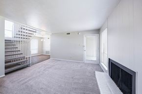 Euless apartment for rent - A spacious room with a fireplace and a staircase.