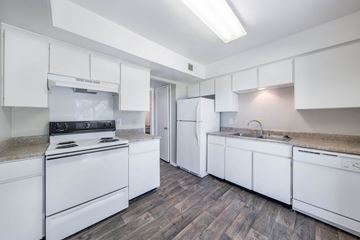 Euless apartment for rent - A kitchen with white appliances and cabinets.