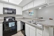 Austin apartment for rent - B1 kitchen with white cabinets and black appliances at Westdale Pointe in Austin, TX