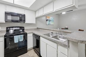 Austin apartment for rent - B1 kitchen with white cabinets and black appliances at Westdale Pointe in Austin, TX