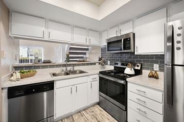 Dallas apartment for rent - an apartment kitchen with stainless steel appliances and white cabinets