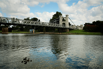Euless apartment for rent - A bridge over a body of water with ducks swimming in the foreground.