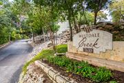Austin apartment for rent - the sign at the corner of a road with trees