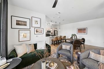 Hurst apartment for rent - A living room with a green couch, a grey couch, a coffee table, and a dining table with chairs.