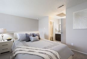 Dallas apartment for rent - a bedroom with a large bed and a bathroom with a sink
