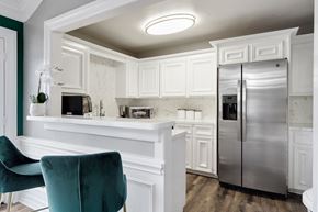 Houston apartment for rent - a kitchen with white cabinets and a silver refrigerator