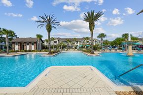 Jacksonville apartment for rent - A large swimming pool with fountains is surrounded by palm trees at Oakleaf Plantation Apartments in Jacksonville, FL