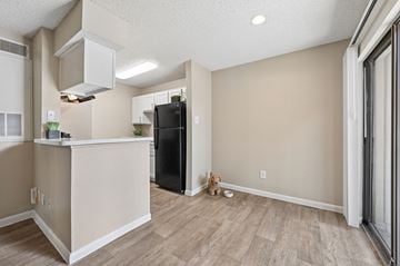 San Antonio apartment for rent - A kitchen area with a black refrigerator and wooden flooring.