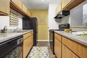 Houston apartment for rent - a kitchen with a black refrigerator freezer next to a stove top oven