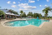 Jacksonville apartment for rent - A large outdoor swimming pool surrounded by a brick patio and a covered pavilion at Wynnfield Lakes Apartments in Jacksonville, FL