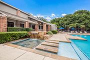 Austin apartment for rent - a swimming pool with a waterfall in front of a house