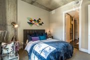 Dallas apartment for rent - Industrial-inspired bedroom with queen sized bed at The Case Building in Dallas, TX