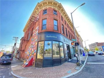 Norwalk apartment for rent - A street view of a Barbershop with a red brick building and a mural on the side.