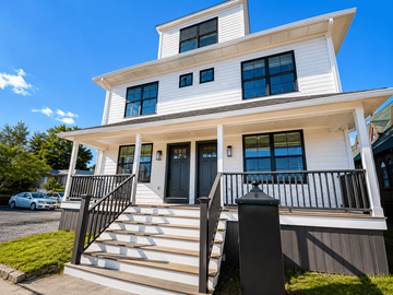 Norwalk apartment for rent - A white two-story house with a black metal railing on the front porch.