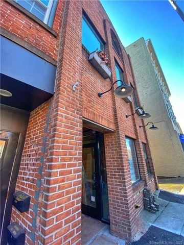 Norwalk apartment for rent - A red brick building with a black door and windows.