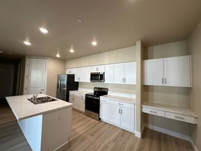 Visalia apartment for rent - A kitchen with white cabinets and a wooden floor.