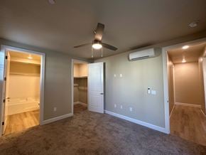 Visalia apartment for rent - A room with a ceiling fan and a wall-mounted air conditioner.